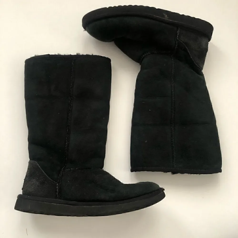 Ugg’s classic tall boots in black shearling lined